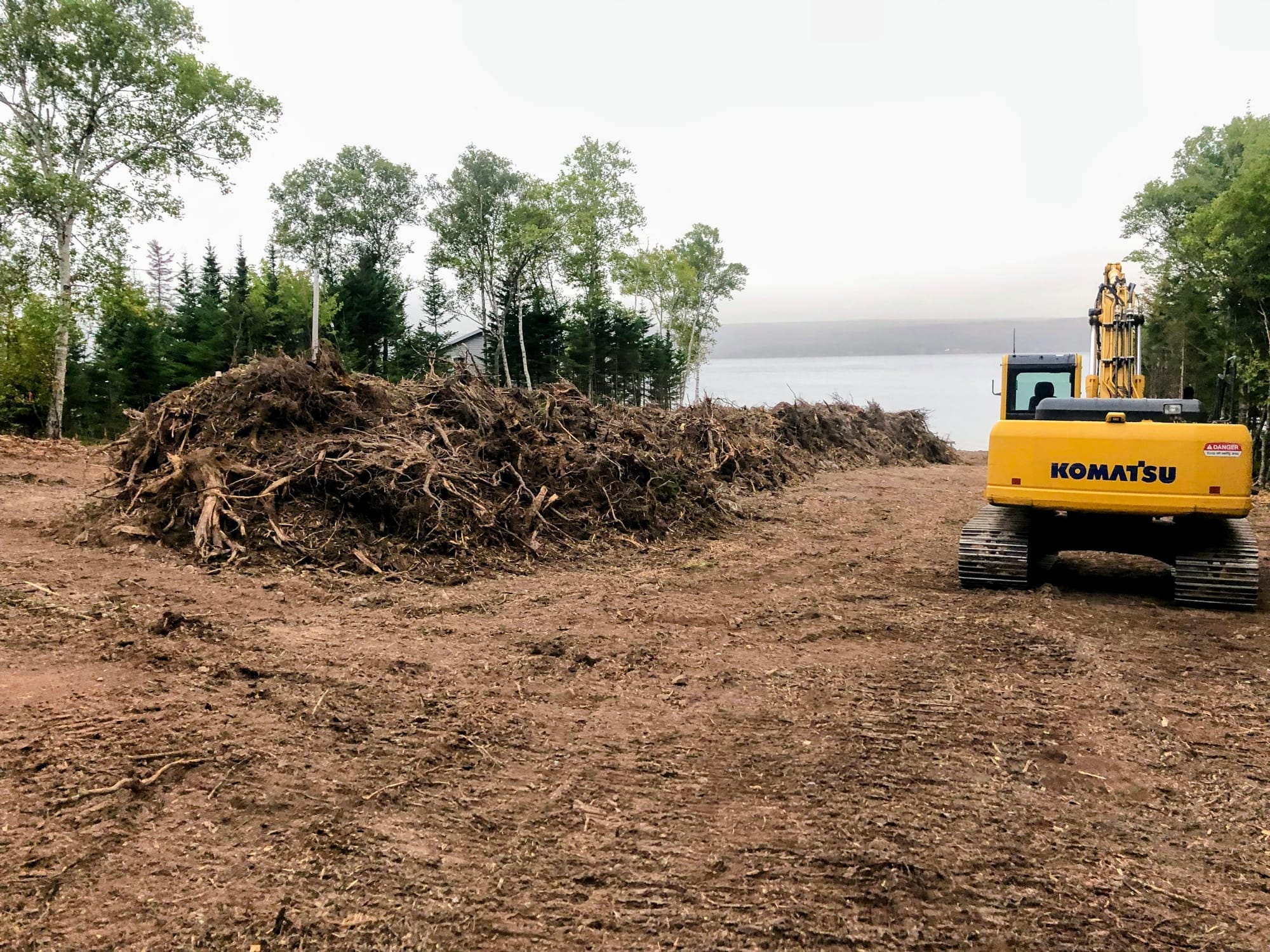 Excavator on waterfront property for road and site preparation